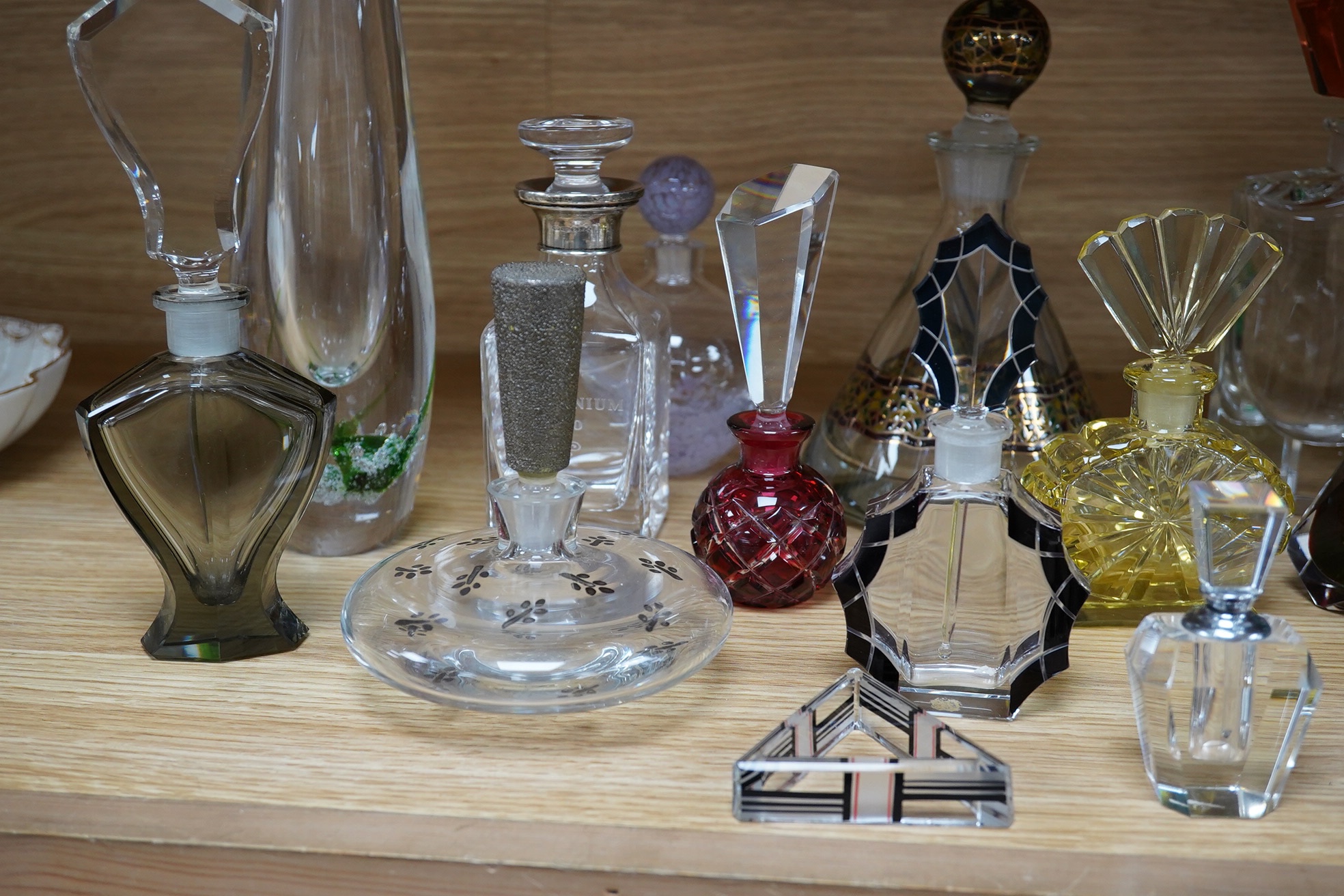 Eighteen glass scent bottles, two silver mounted, tallest 24.5cm, and a glass vase. Condition - good